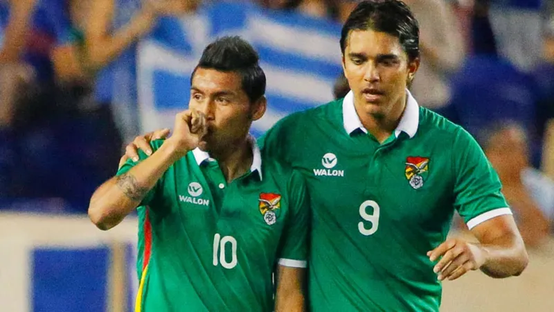 Cầu thủ Iraq và Bolivia tranh chấp bóng trên sân cỏ